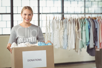 Portrait of beautiful woman holding clothes donation box