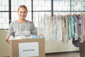 Portrait of beautiful woman holding clothes donation box