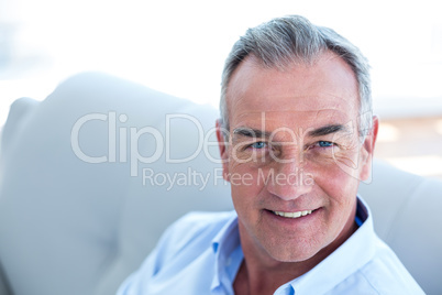 Happy man sitting on sofa at home