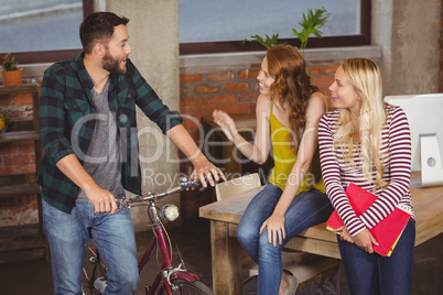 Man standing with bicycle and discussing