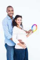 Portrait of smiling husband with wife holding color wheel