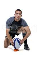 Portrait of rugby player in black jersey placing ball