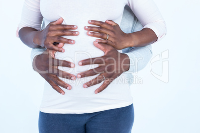 Mid section of man along with wife touching belly