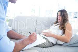 Psychiatrist advising preganant woman relkaxing at home
