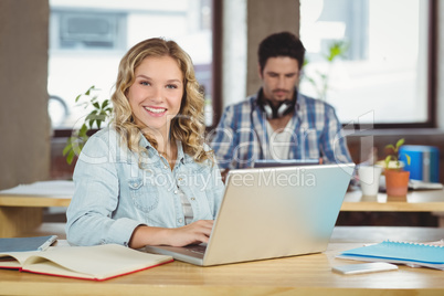 Portrait of beautiful woman with laptop in office