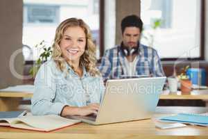 Portrait of beautiful woman with laptop in office