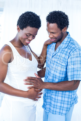 Happy husband touching belly of pregnant wife