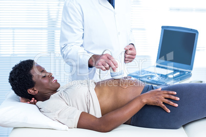 Happy pregnant woman looking at doctor