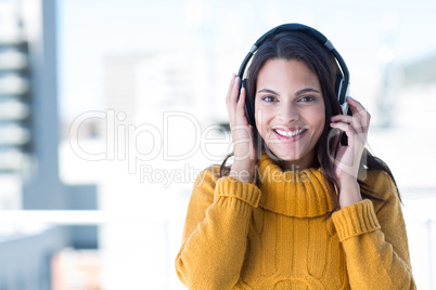 Pretty woman listening music through headphones