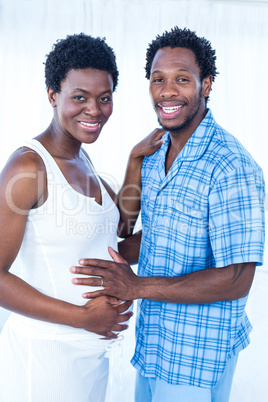 Portrait of happy husband touching belly