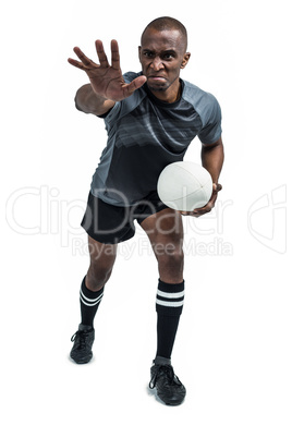 Aggressive rugby player gesturing while holding ball