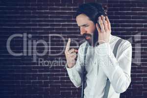 Serious hipster with eyes closed listening music