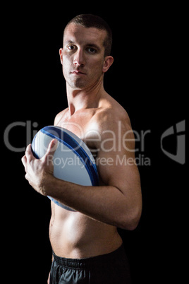 Portrait of handsome shirtless sports player holding ball