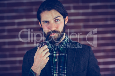 Portrait of confident man smoking pipe