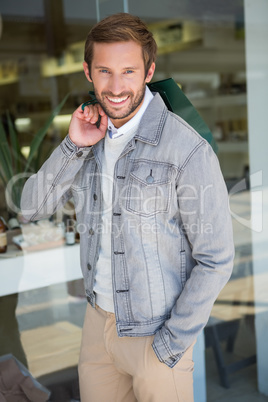 Young happy smiling man holding shopping bags