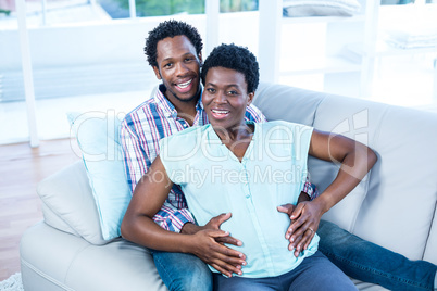 High angle portrait of happy couple relaxing on couch