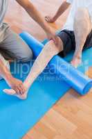 Trainer working with man on exercise mat