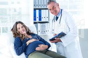 Portrait of doctor and pregnant woman in clinic