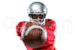 American football player in red jersey holding ball