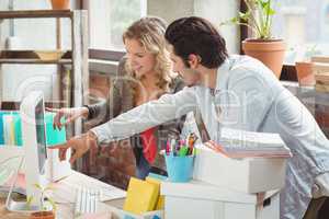 Colleagues pointing towards computer in office