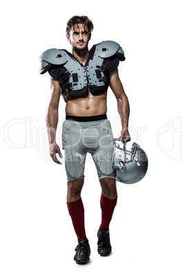 Shirtless American football player with padding holding helmet