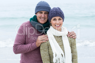 Smiling happy couple both wearing scarfs and hats