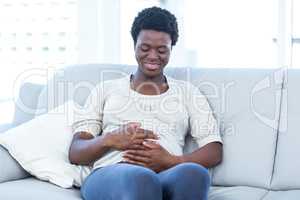 Happy pregnant woman sitting at home