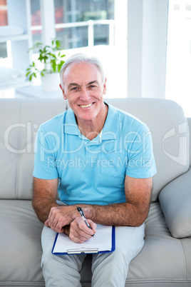 High angle view of happy senior man with clipboard