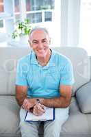 High angle view of happy senior man with clipboard