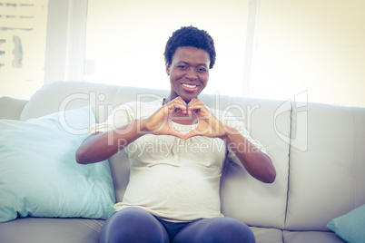 Portrait of pregnant woman making heart shape with hands
