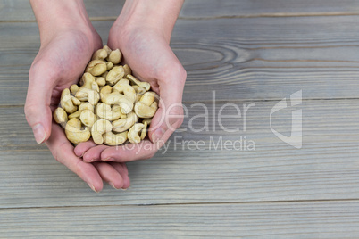 Woman showing handful of cashews