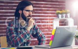 Confident businessman using laptop on desk