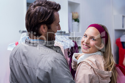 Smiling man having arm around girlfriend looking at camera