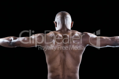 Rear view of muscular athlete with arms outstretched