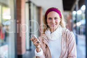 Smiling woman holding smartphone