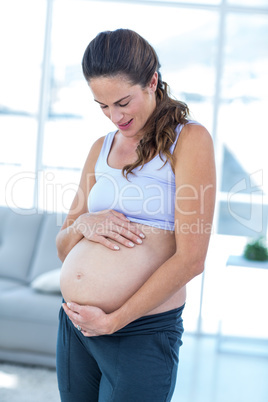 Pregnant woman looking at belly