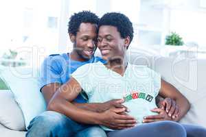 Happy pregnant woman with husband touching her belly