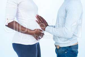 Man touching his pregnant wife belly while standing