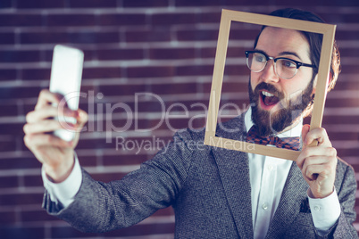 Smart man taking selfie while holding frame