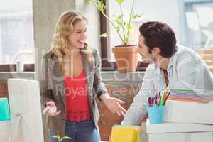 Young businesswoman talking to male colleague in office