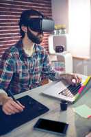 Focused creative businessman using 3D video glasses and laptop