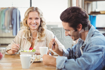 Smiling woman having breakfast with colleague in office