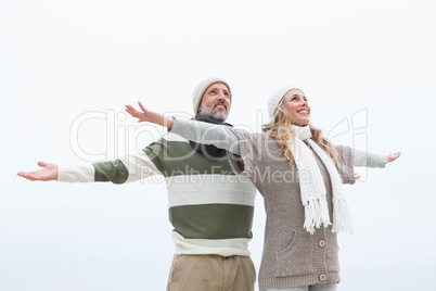 Cute couple standing with arms open wide