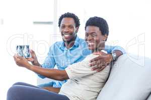 Happy couple showing photo at home