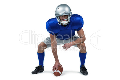 Full length of American football player placing ball