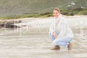 Woman crouching at the shore