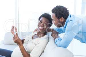 Pregnant woman showing photo to husband