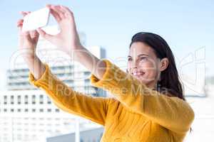 Pretty brunette taking photos with her smartphone