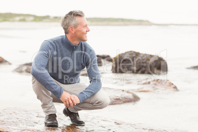 Man crouched down on a large rock