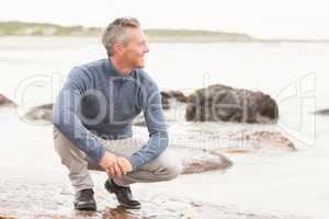 Man crouched down on a large rock
